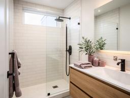 Bright remodeled bathroom with tiled shower and modern vanity